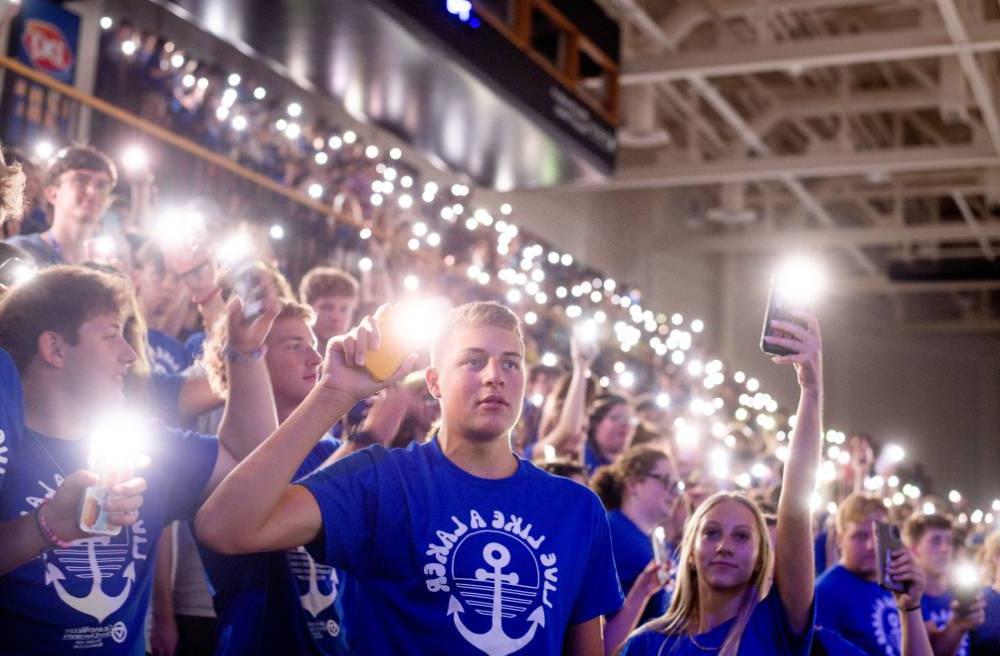 Students holding up cell phone lights during Convocation